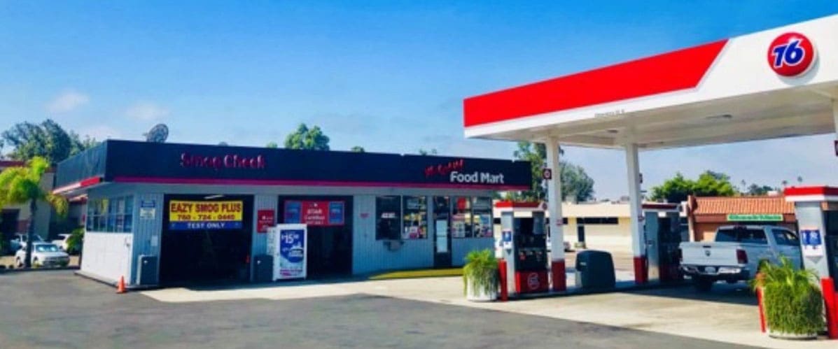 A gas station with a red and white sign on the side.