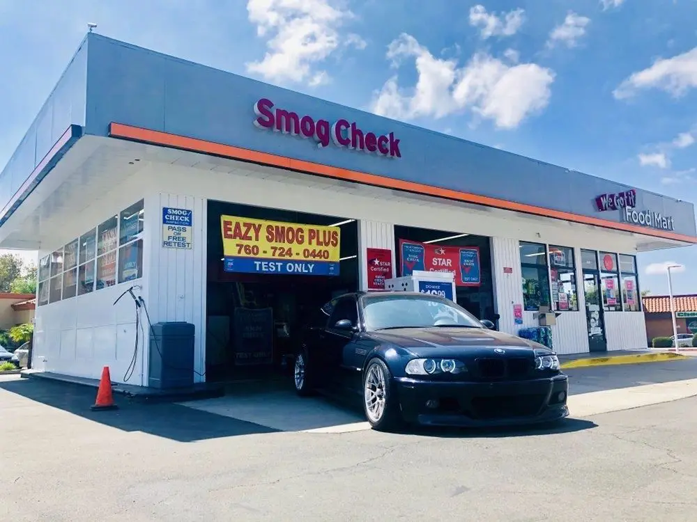 A car is parked in front of the smog check station.