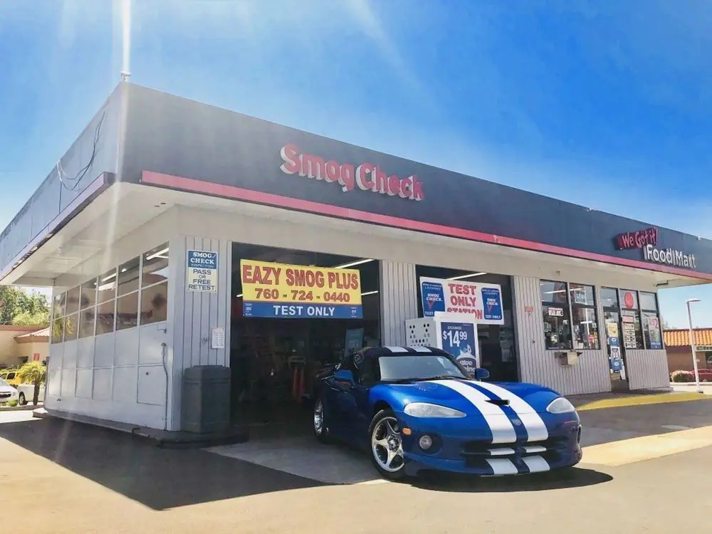 A blue car parked in front of a garage.