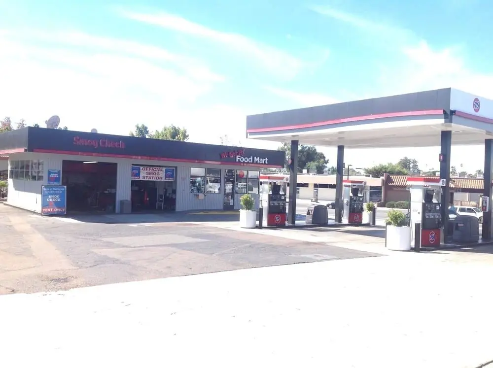 A gas station with two pumps and a red roof.