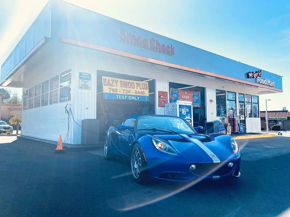 A blue car is parked in front of a gas station.