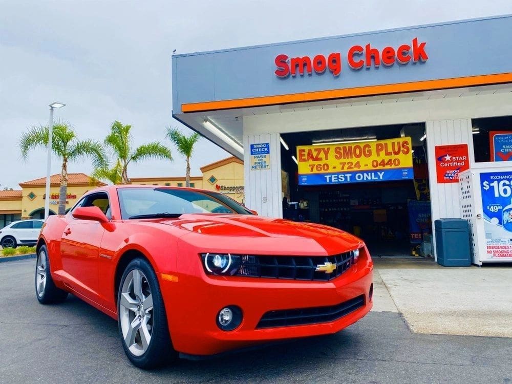 A red car parked in front of a garage.