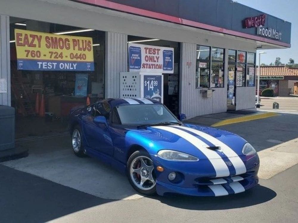 A blue sports car parked in front of a store.