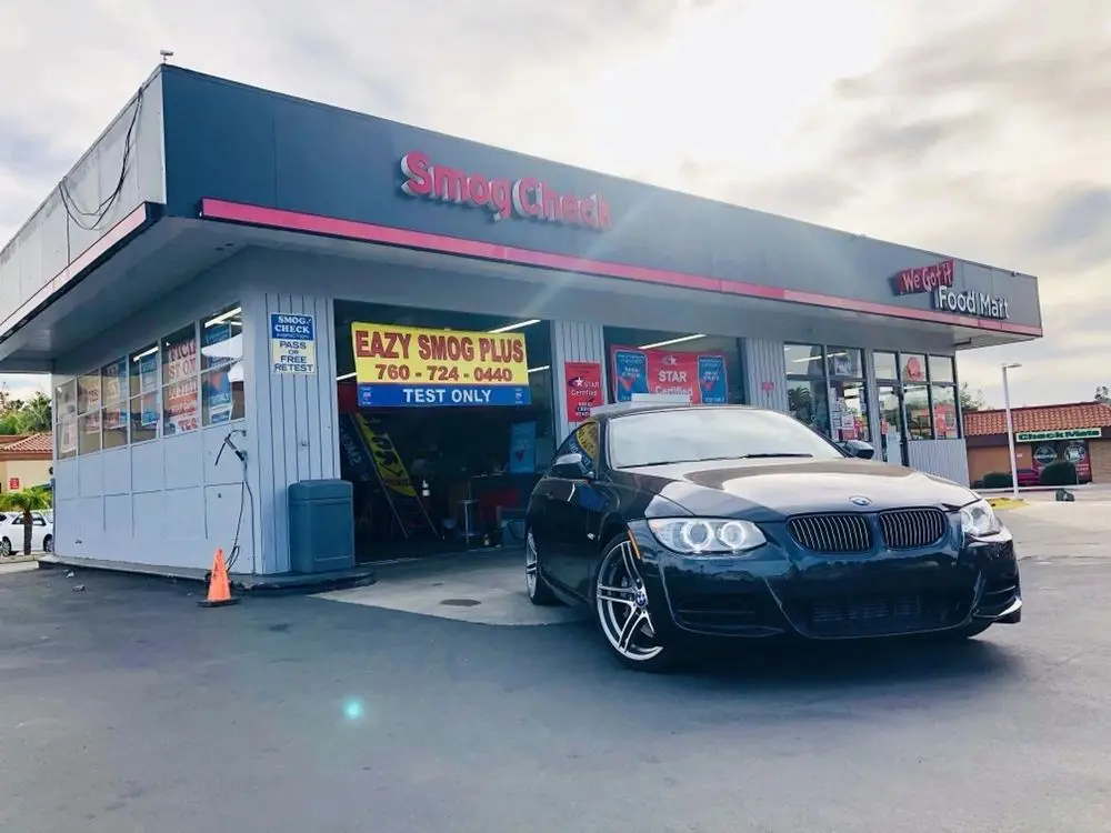 A black bmw parked in front of a service station.